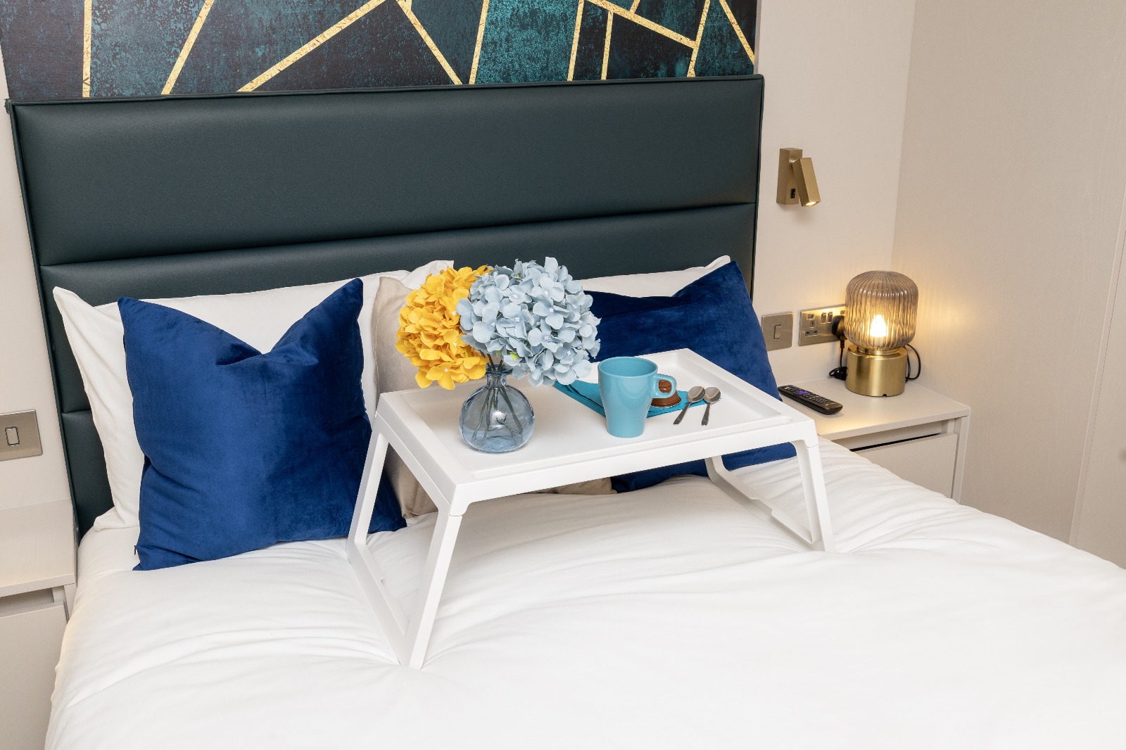 Bedroom with breakfast tray and fresh hydrangeas at Crownverge Brent Cross West